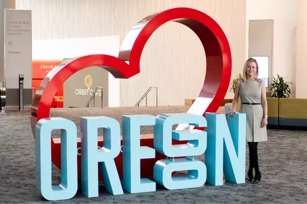 Cassidy Campanian standing next to a large Oregon sign backed by a red heart.
