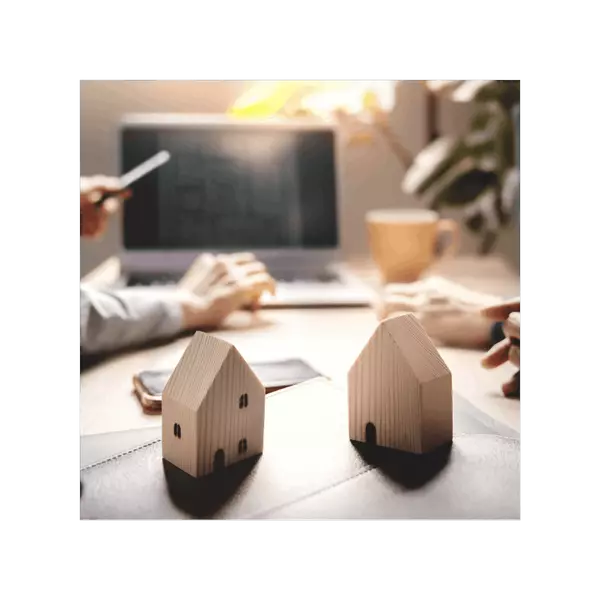 Two wooden block homes with hands at the computer representing preparation and strategy for selling your Portland home.