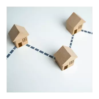 Wood model homes connected by dashed lines representing real estate strategy, collaboration, and planning your home sale.