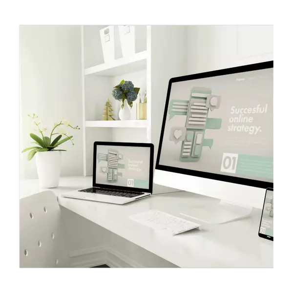 Clean white workspace with desktop computer and laptop both showing a multi-channel online marketing interface.