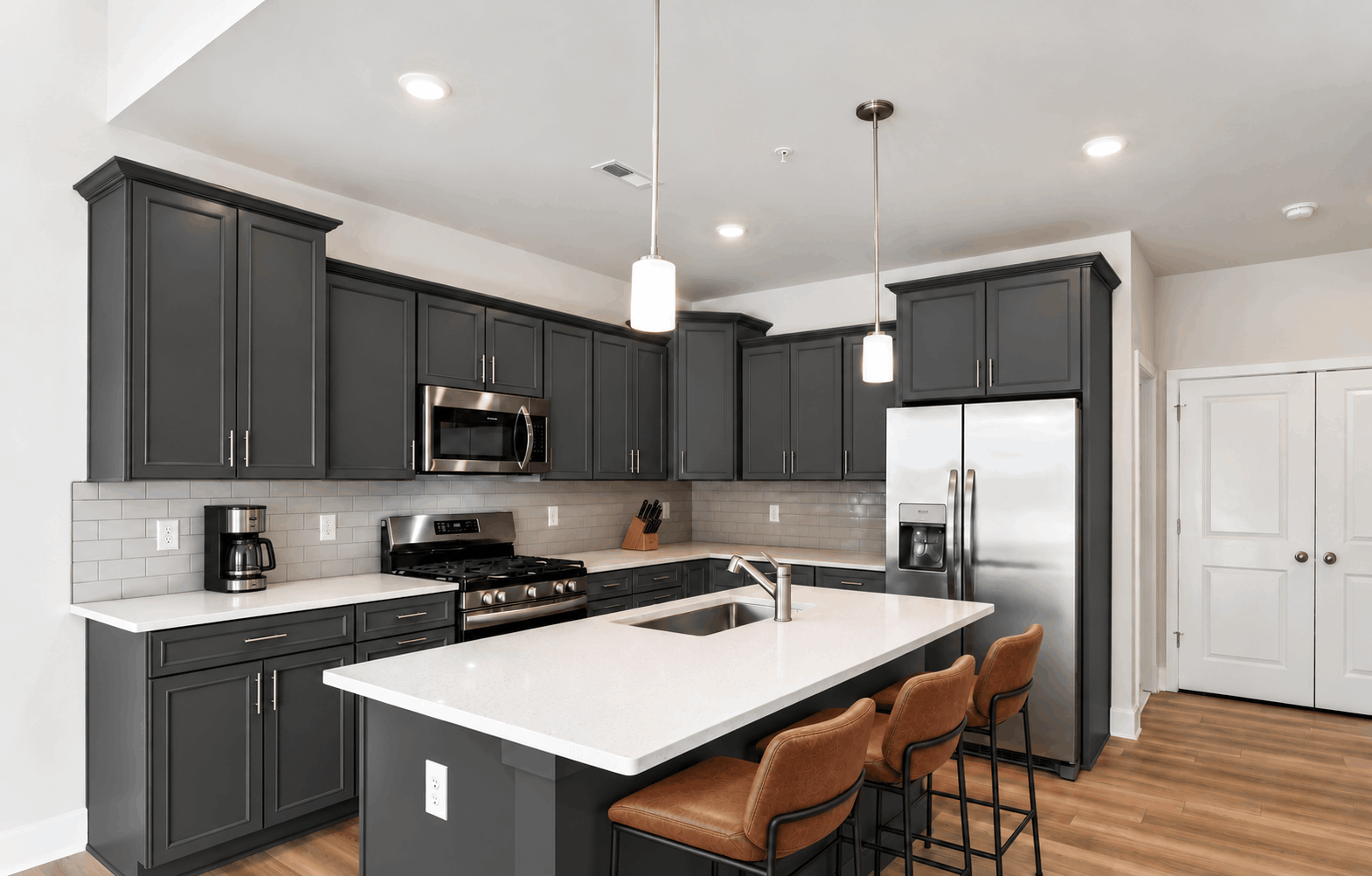 Kitchen with dark cabinets and a center island with cognac bar stools in a White Plains, MD home