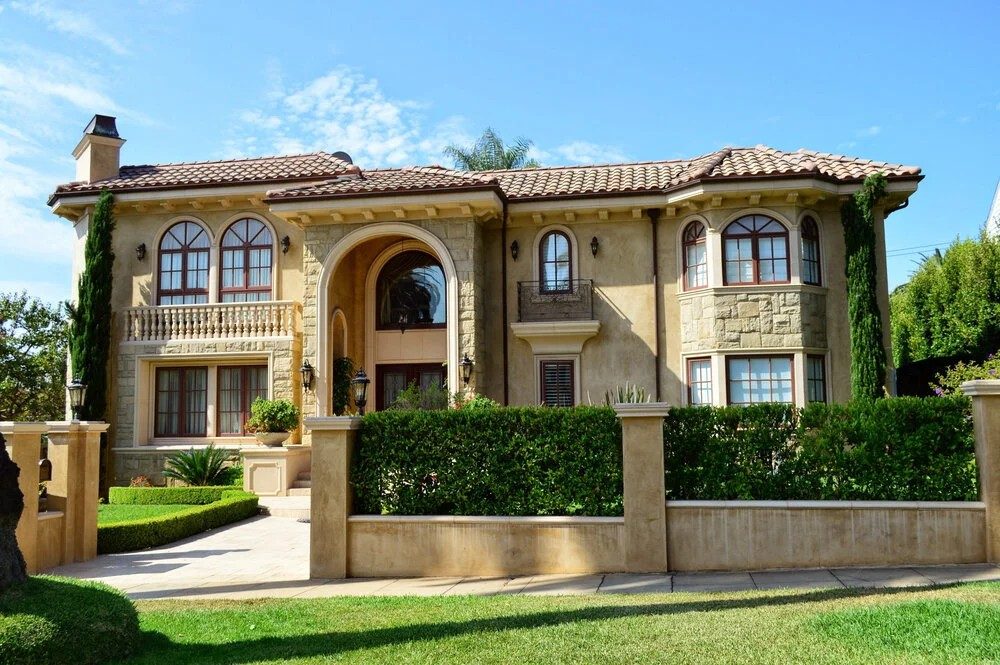 Photo of an elegant mansion-style home with columns and landscaping, landscape orientation