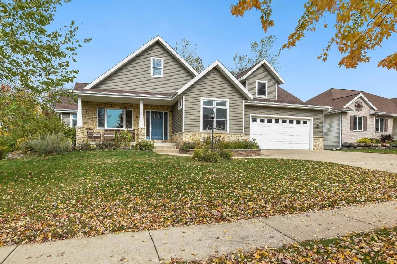 Photo of a larger family home on a tree-lined street with driveway, landscape orientation