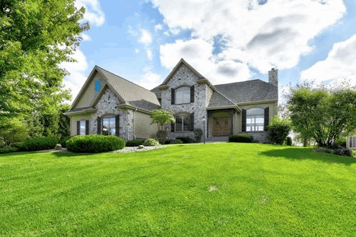 Photo of a traditional suburban house with green lawn, landscape orientation