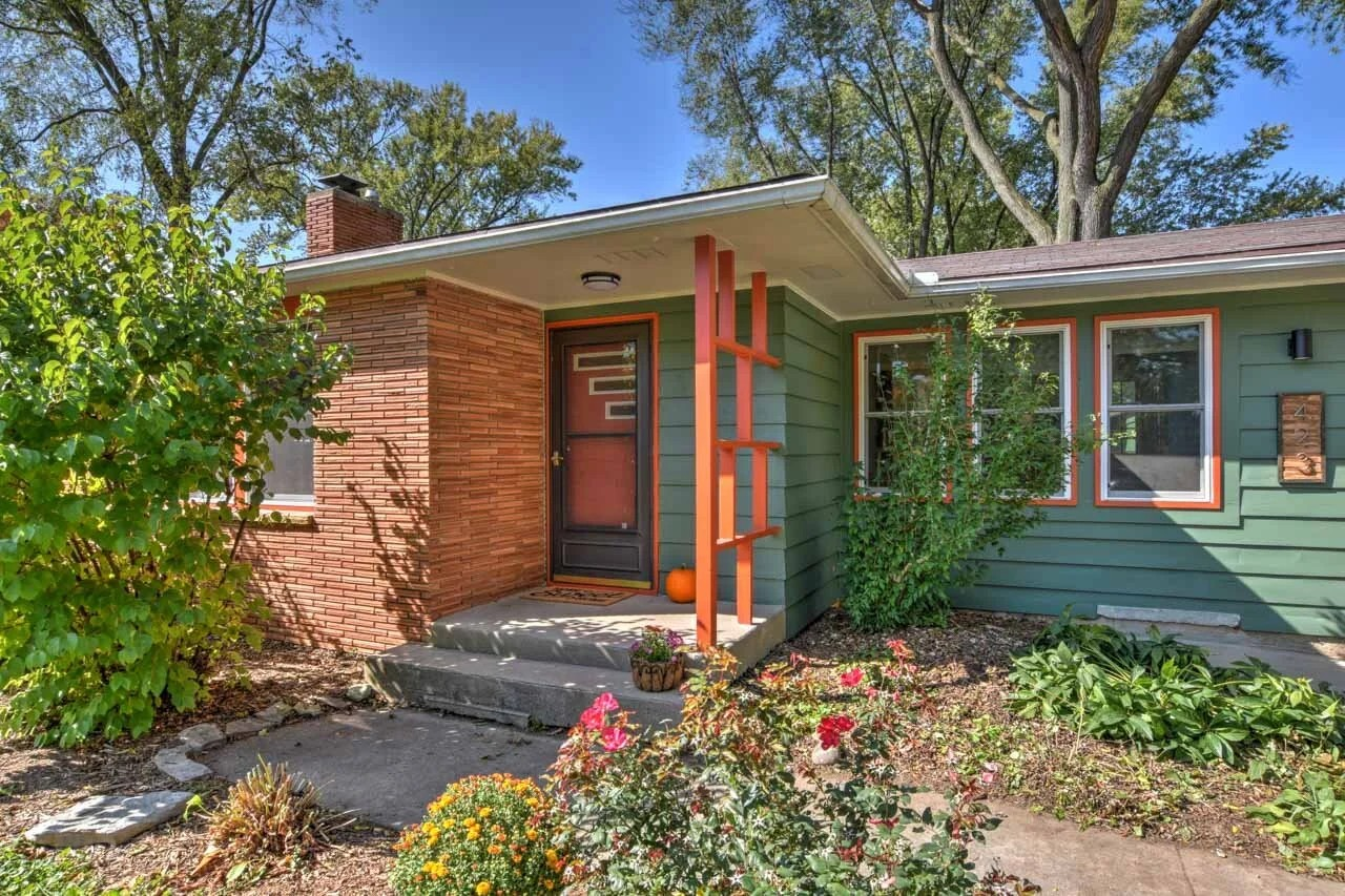 Photo of a cozy bungalow with garden and pathway, landscape orientation