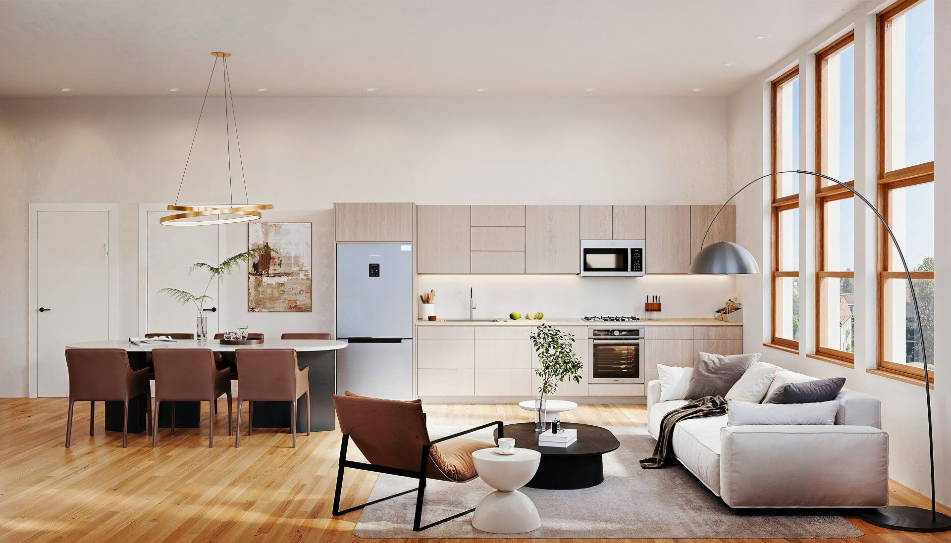 Bright modern open-plan living and kitchen area with wooden floor, dining table, armchairs and sofa, seen from an angle showing the full space