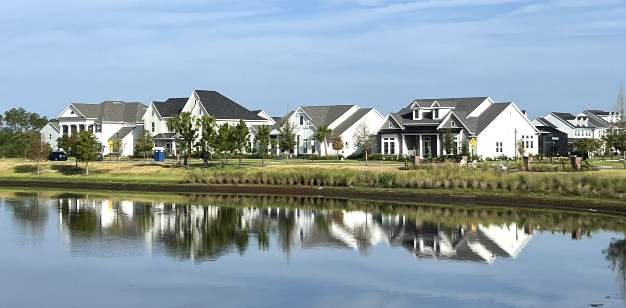 Variety of newer homes overlooking a lake in Seven Pines, Jacksonville, Florida, showing different architectural styles and landscaped surroundings.