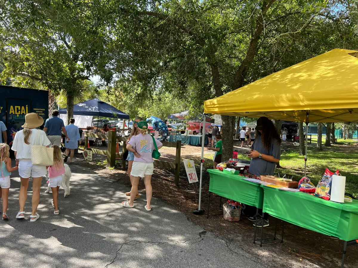 Outdoor community market with local vendors and residents in Atlantic Beach, Florida.