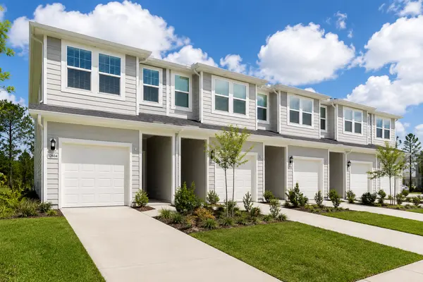 Modern two-story townhomes in Mandarin, Jacksonville, Florida, featuring attached garages, contemporary architecture, landscaped lawns, and low-maintenance living.