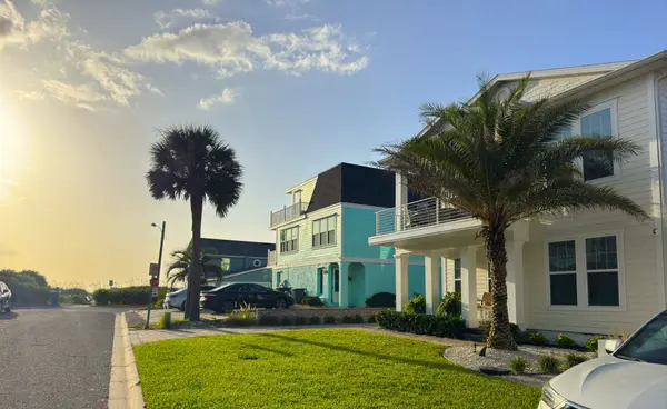 Modern coastal homes on a palm-lined residential street in Jacksonville Beach, Florida, showcasing the area's relaxed beachside neighborhoods and walkable coastal lifestyle.