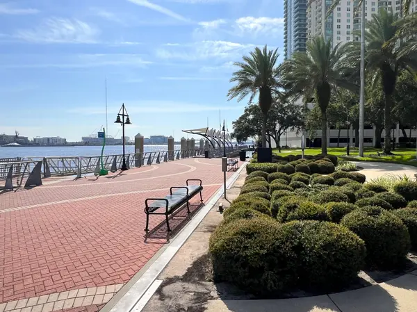 People walking along the Southbank Riverwalk beside the St. Johns River in Jacksonville, Florida.