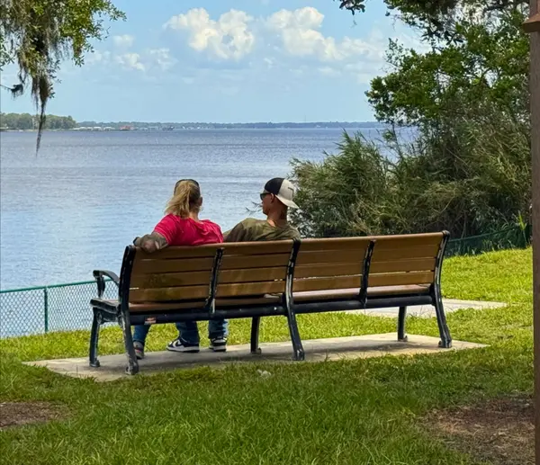 Couple sitting on a bench, enjoying a river view.