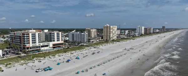 Aerial view of the Jacksonville Beach coastline with sandy beaches, oceanfront homes, and condominium buildings.