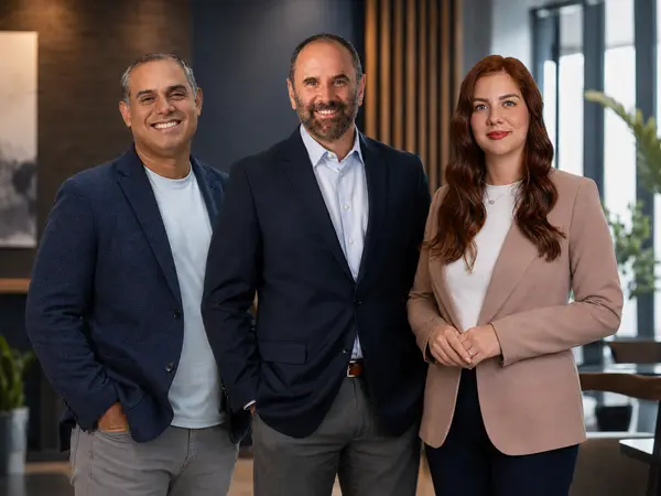 Tu Familia Real Estate leadership team standing together in a professional office setting.