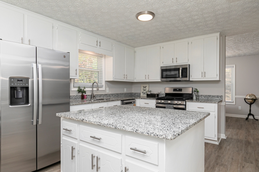 Updated kitchen with granite island white cabinets and stainless steel appliances in Woodstock GA