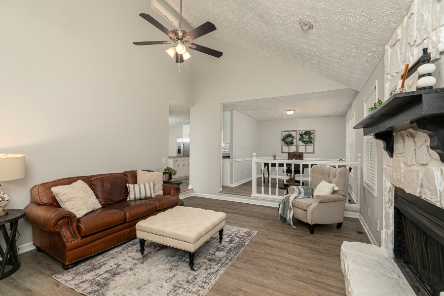 Vaulted ceiling family room with floor-to-ceiling stone fireplace in Woodstock GA home