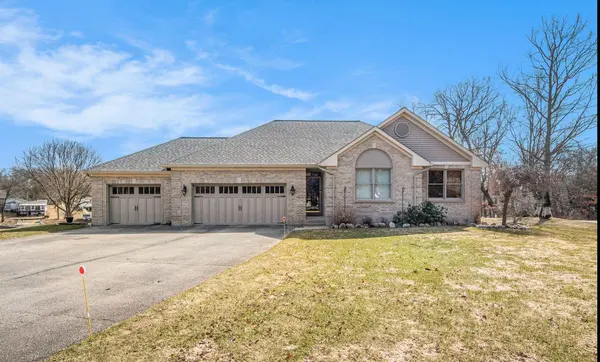 Spacious brick ranch home with three-car attached garage, large driveway, and landscaped front yard. 💙