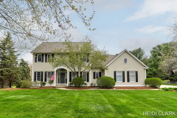 Beautiful two-story traditional home with cream siding, black shutters, mature trees, and a spacious landscaped front lawn.