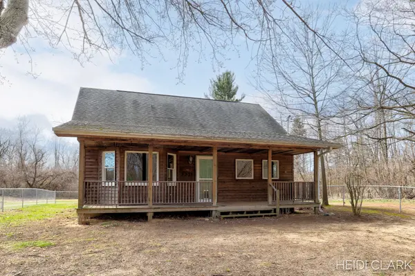 Rustic log cabin with natural wood siding, a spacious covered front porch, and a peaceful wooded setting. 💙