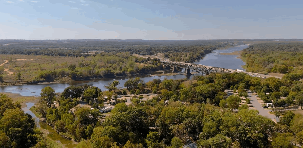 winding Red River border showing the green landscape of North Texas on one side and Southern Oklahoma on the other.