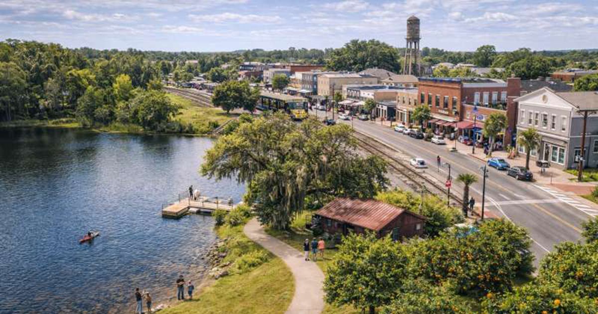 Aerial view of downtown Inverness Florida with lakefront water tower and historic brick buildings in Citrus County