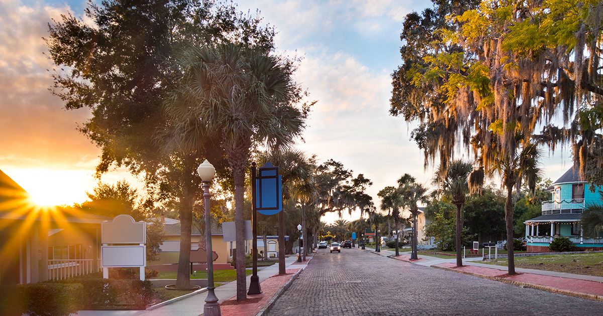Historic brick-lined street with Spanish moss and palm trees at sunset in Tarpon Springs Florida Pinellas County