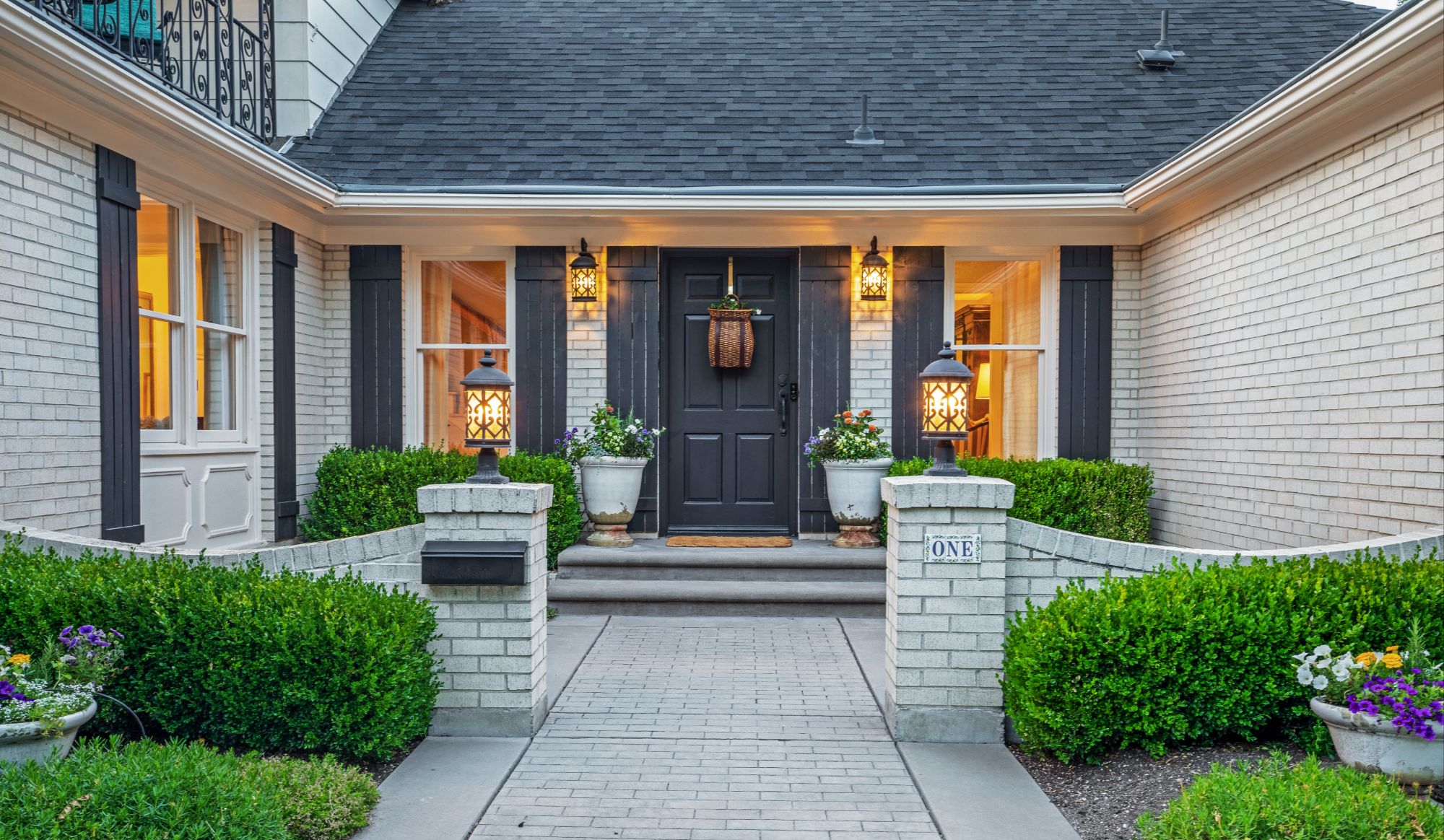 a-white-brick-house-with-a-black-door-and-grey-shutters