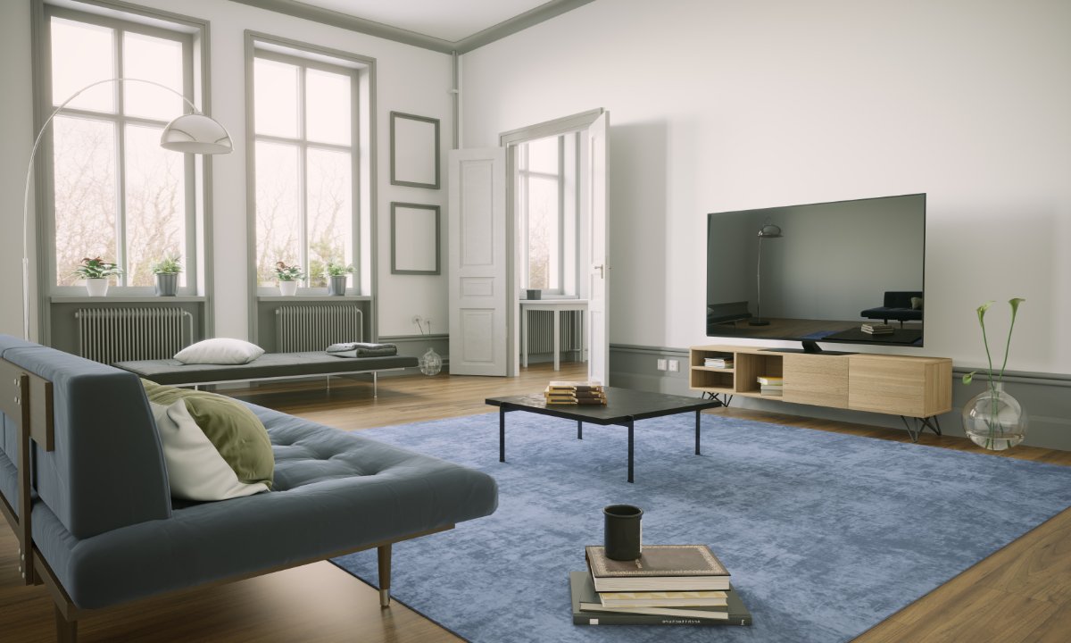 Minimalist living room with large windows, simple furnishings and light-filled interior featuring a TV console and soft rug.