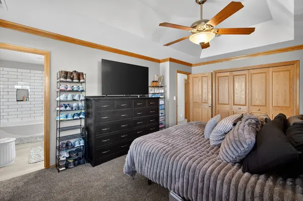 This bedroom features a tray ceiling and ample closet space
