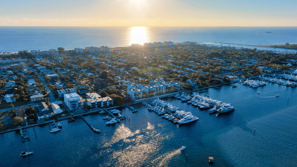 Aerial view of a Palm Beach County marina and waterfront neighborhood at sunrise
