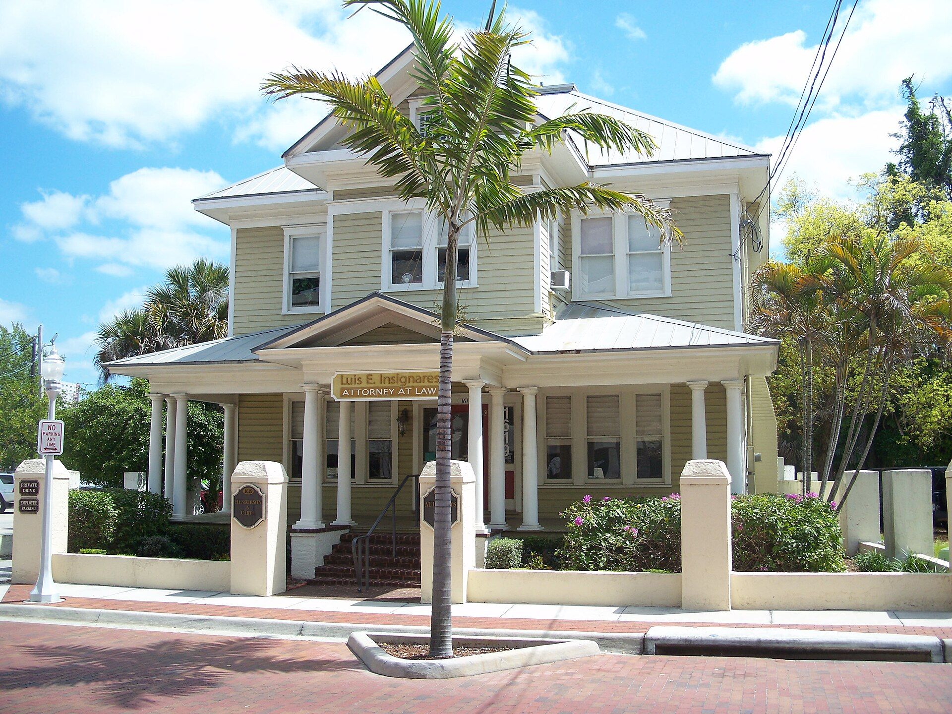 Historic two-story building with a front porch and palm tree in the Fort Myers downtown historic district