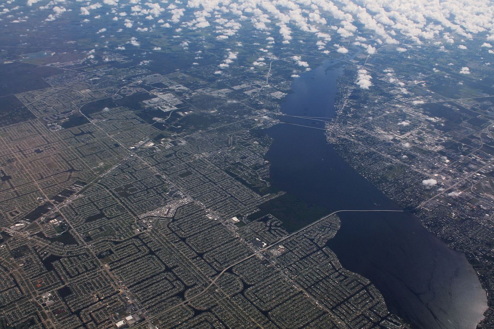 Aerial view of Cape Coral neighborhoods and canals along the Caloosahatchee River, with Fort Myers across the river