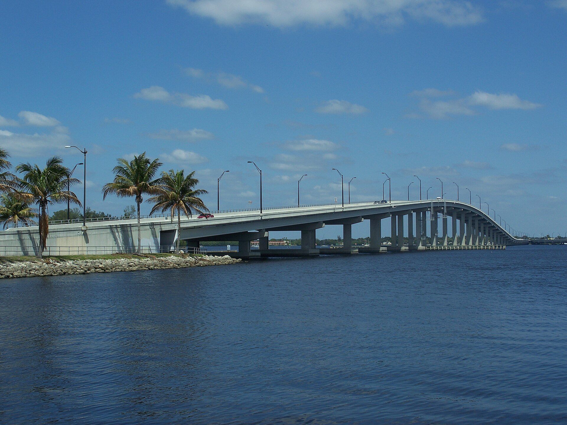 The Caloosahatchee River and the US 41 Edison Bridge in Fort Myers, Florida, with palm trees on the riverbank