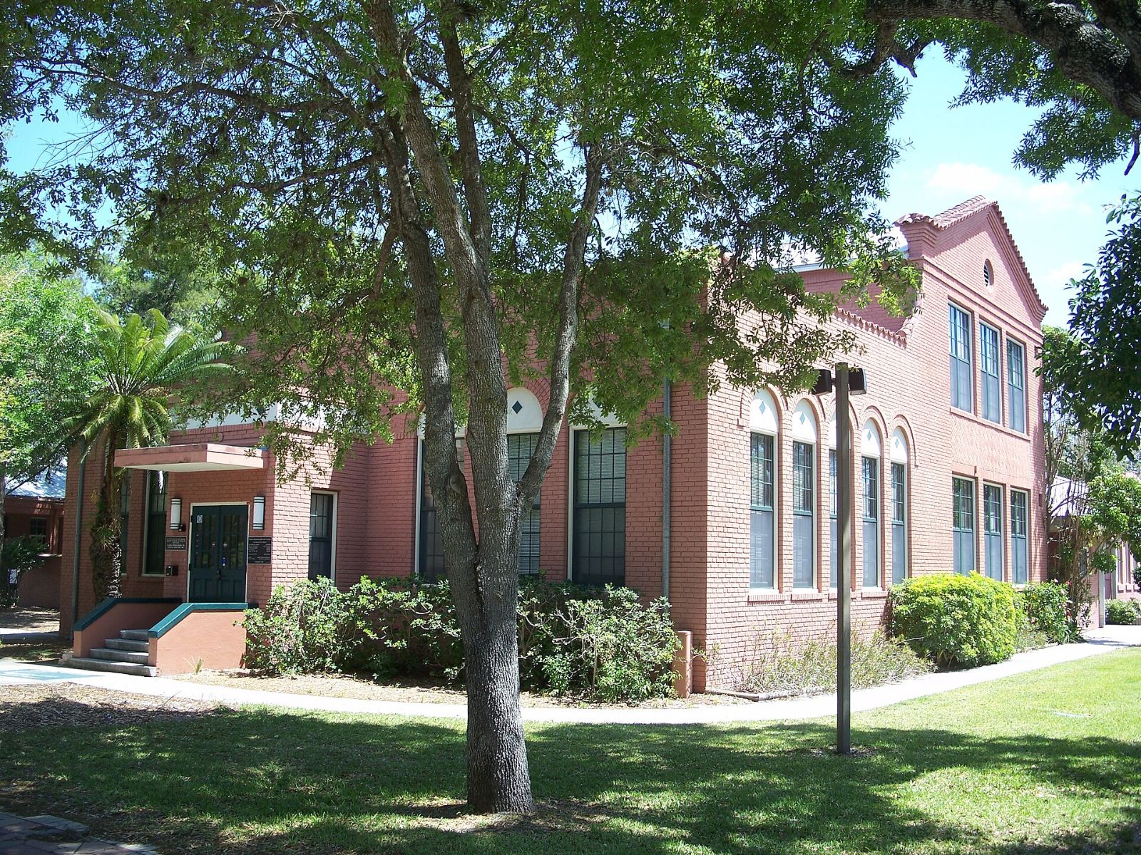 The historic red-brick Bonita Springs School building with palm trees