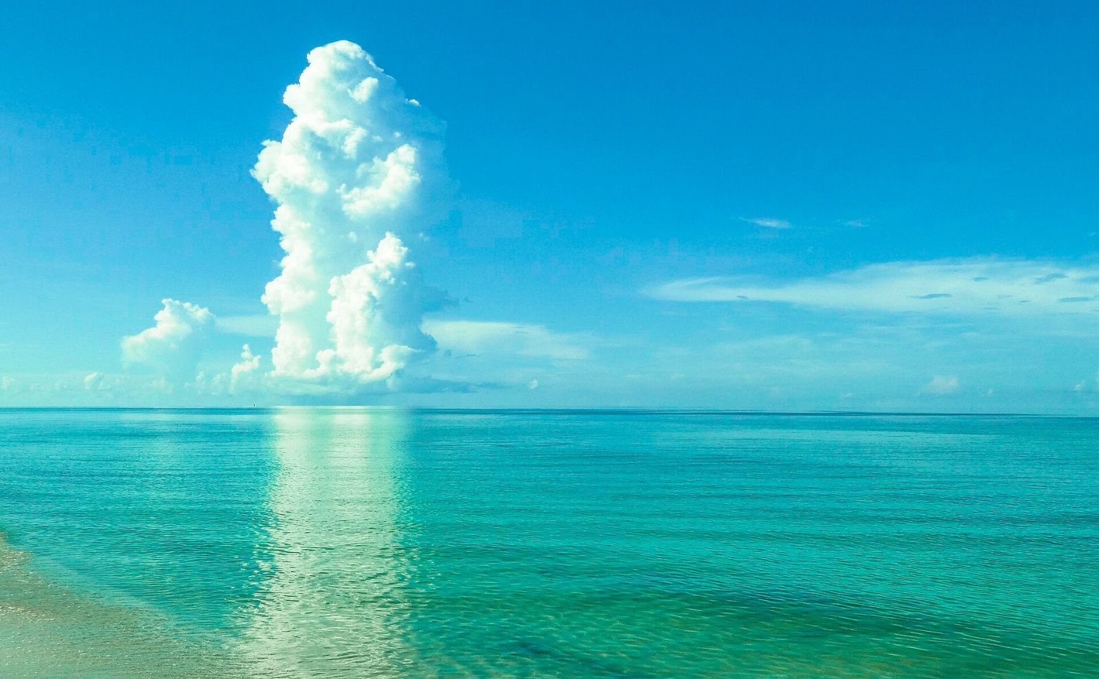 Turquoise Gulf water and a tall cloud at Vanderbilt Beach, Naples, Florida