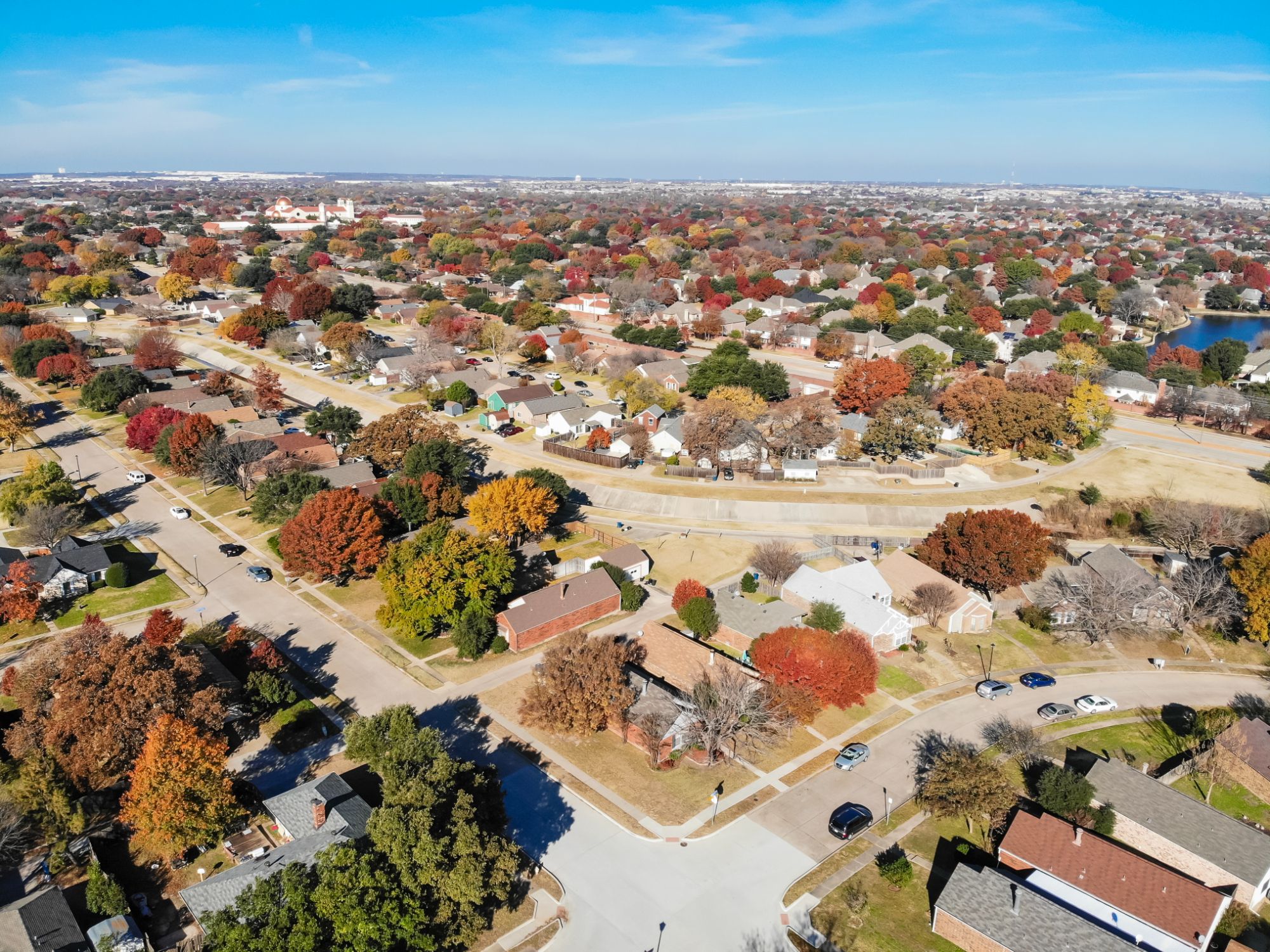Aerial view of a lakeside single-family neighborhood in Coppell, Texas in autumn