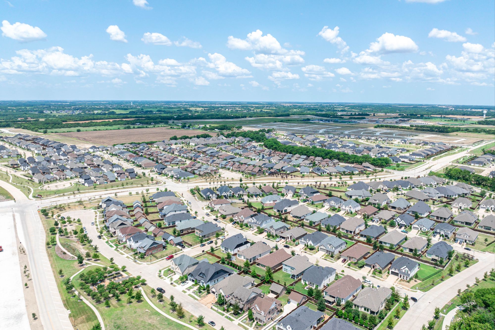 Aerial view of new home construction in Anna, Texas, surrounded by open land