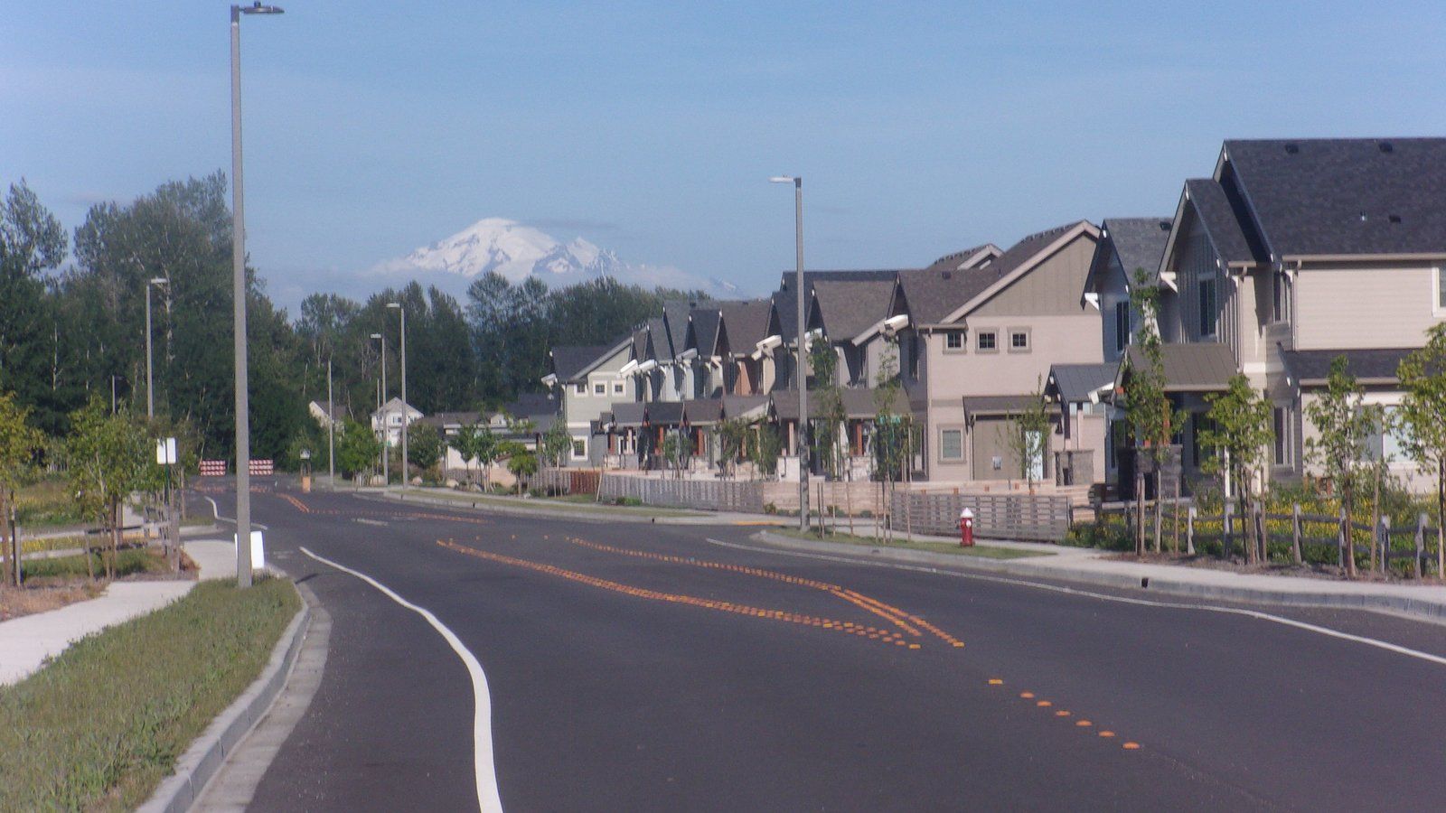 Rows of newer two-story townhomes along curving Kline Road in Bellingham's Cordata neighborhood, with Mount Baker in the distance.