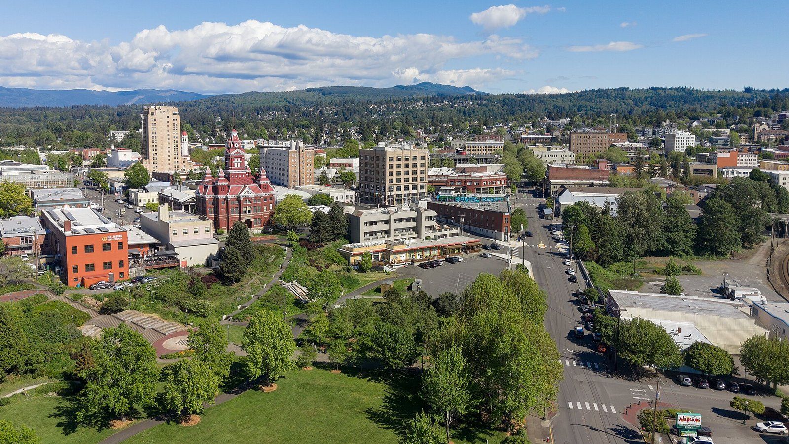 Aerial view of downtown Bellingham, with the red-brick Old City Hall clock tower, Maritime Heritage Park and the hills beyond.