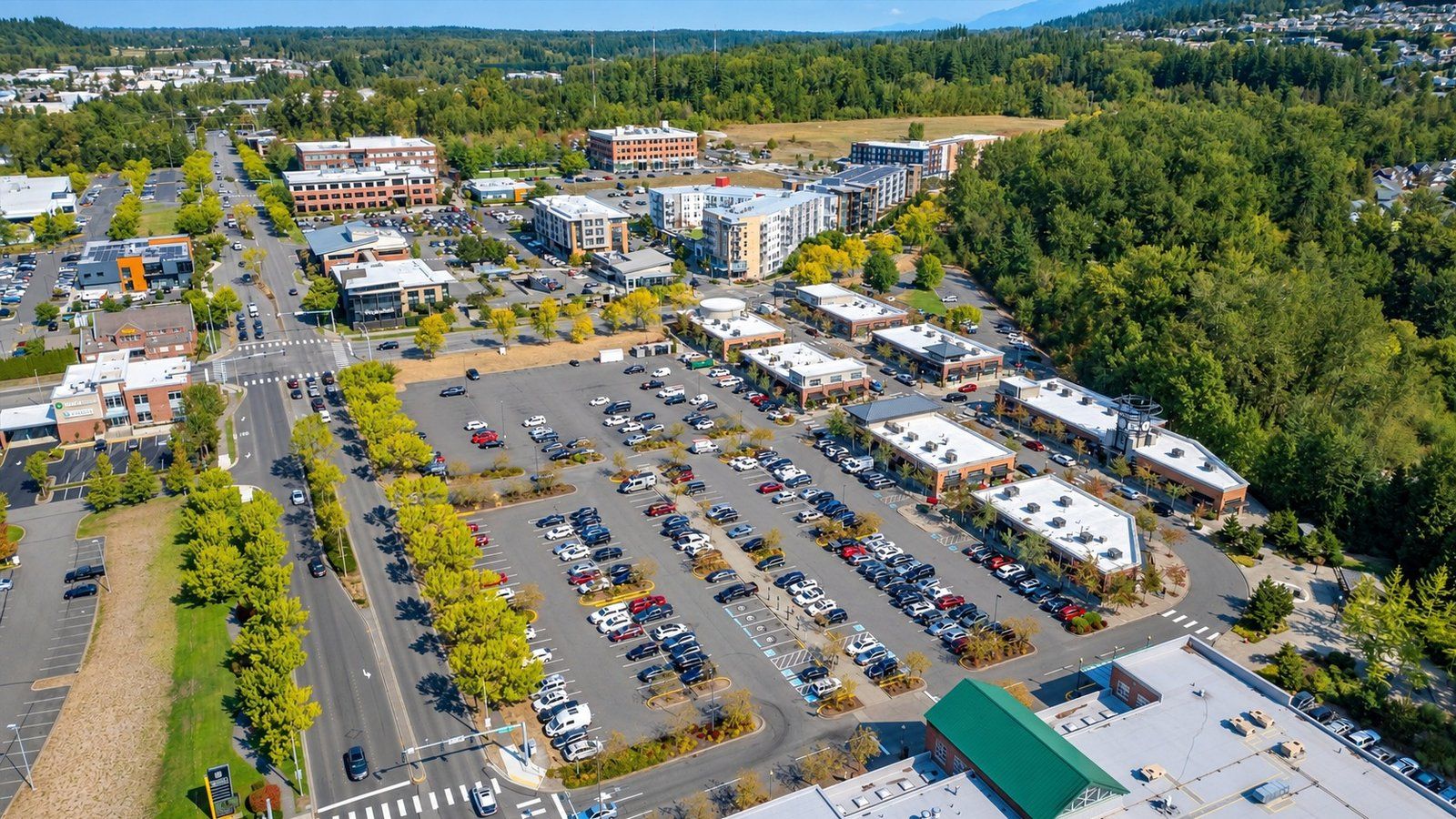 Aerial view of Barkley Village in Bellingham, with shops, parking, apartments and tree-lined streets.