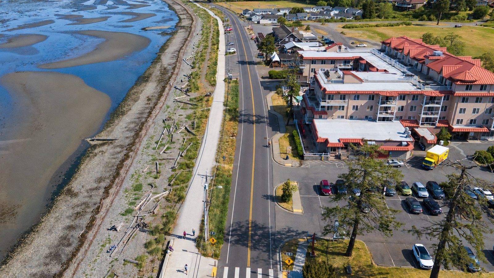 Aerial view of Birch Bay Drive in Birch Bay, Washington, with the berm walkway, tide flats, condos and shops.