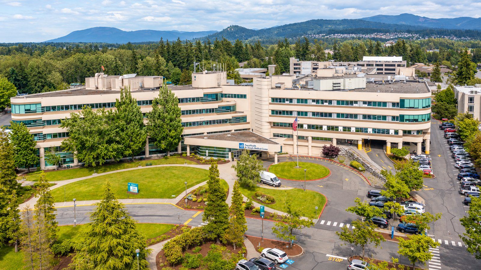 Aerial view of PeaceHealth St. Joseph Medical Center in Bellingham, with its main entrance, lawn and parking.