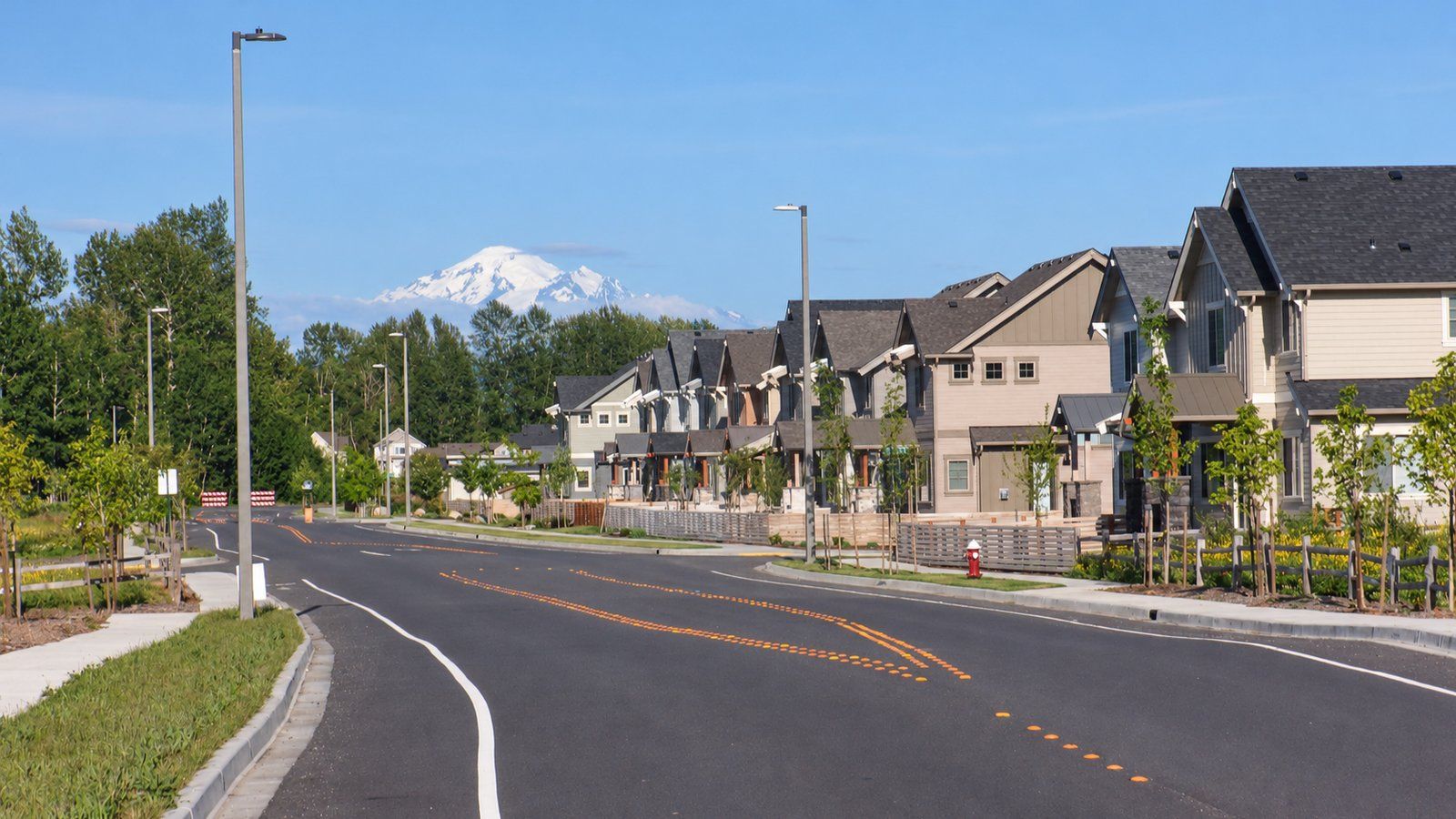 Rows of newly built homes along a freshly paved road in the Cordata area of north Bellingham, with Mount Baker in the distance.