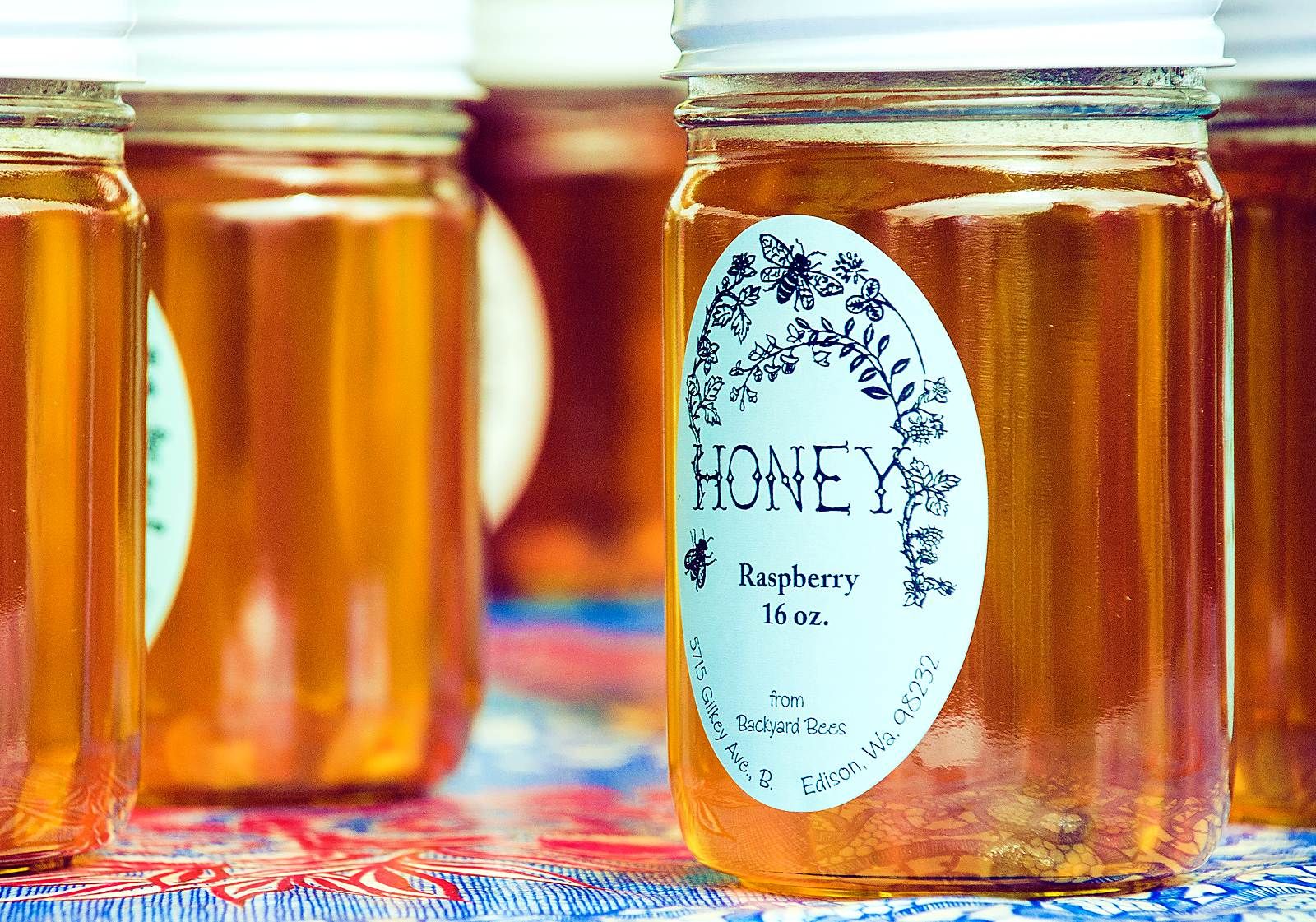 Jars of local raspberry honey for sale at the Bellingham Farmers Market, part of grocery costs in Bellingham WA