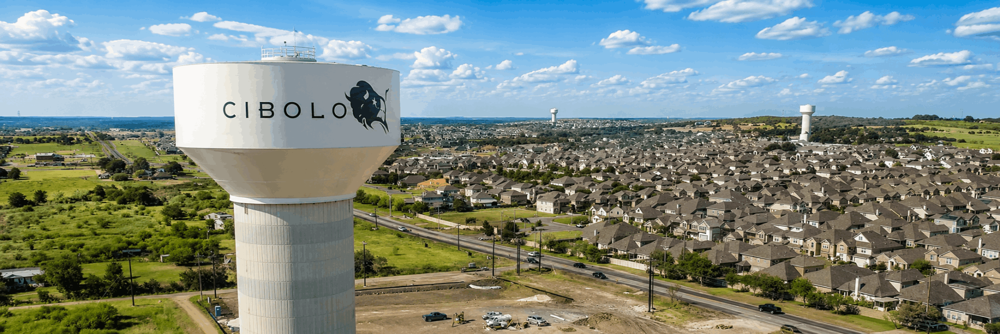 Aerial view of the Cibolo, Texas water tower overlooking residential neighborhoods, new homes, and community growth in one of the fastest-growing cities near San Antonio.