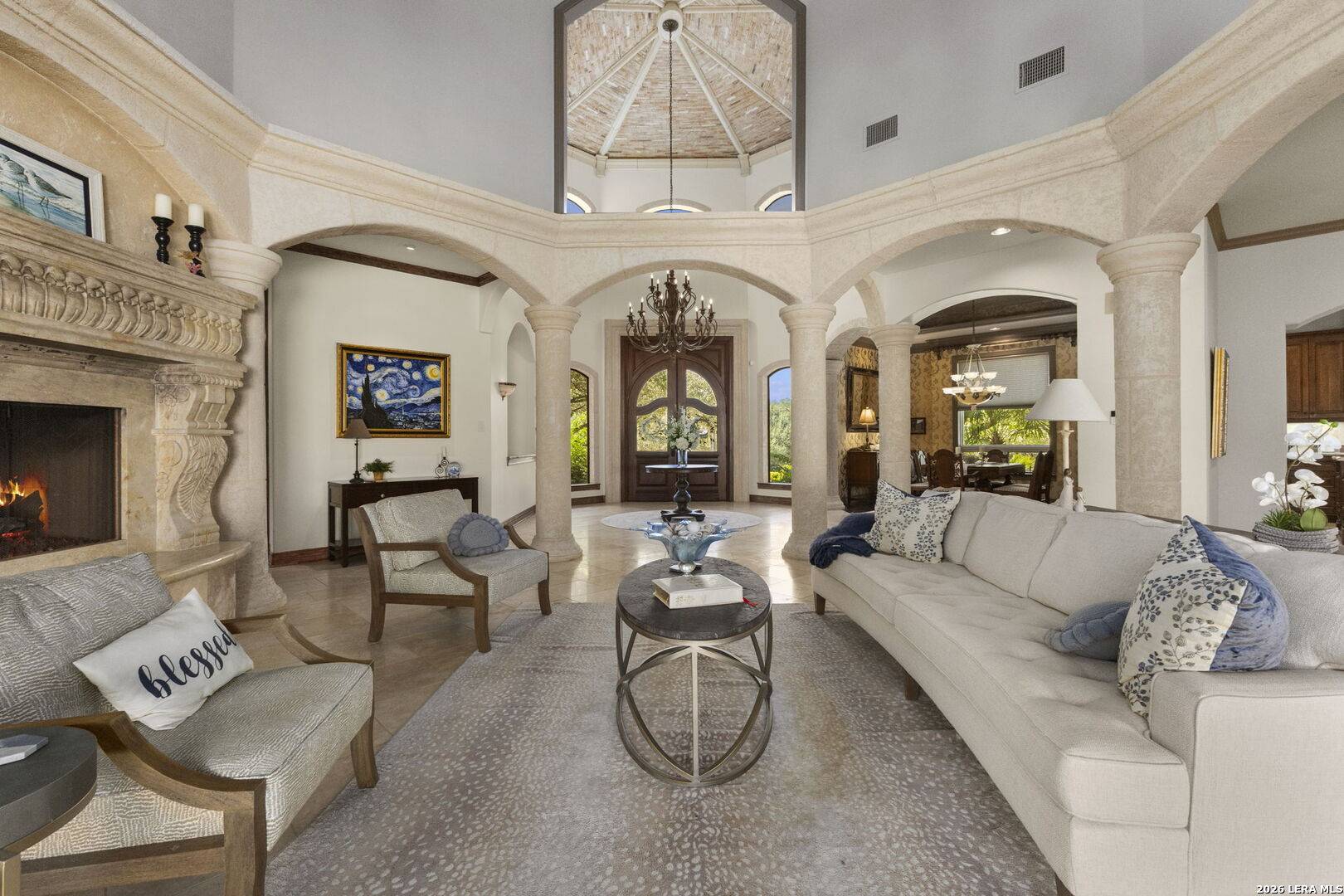 Formal living room of 2 Belcourt Place with bell-tower ceiling, arched windows, columns and travertine floors
