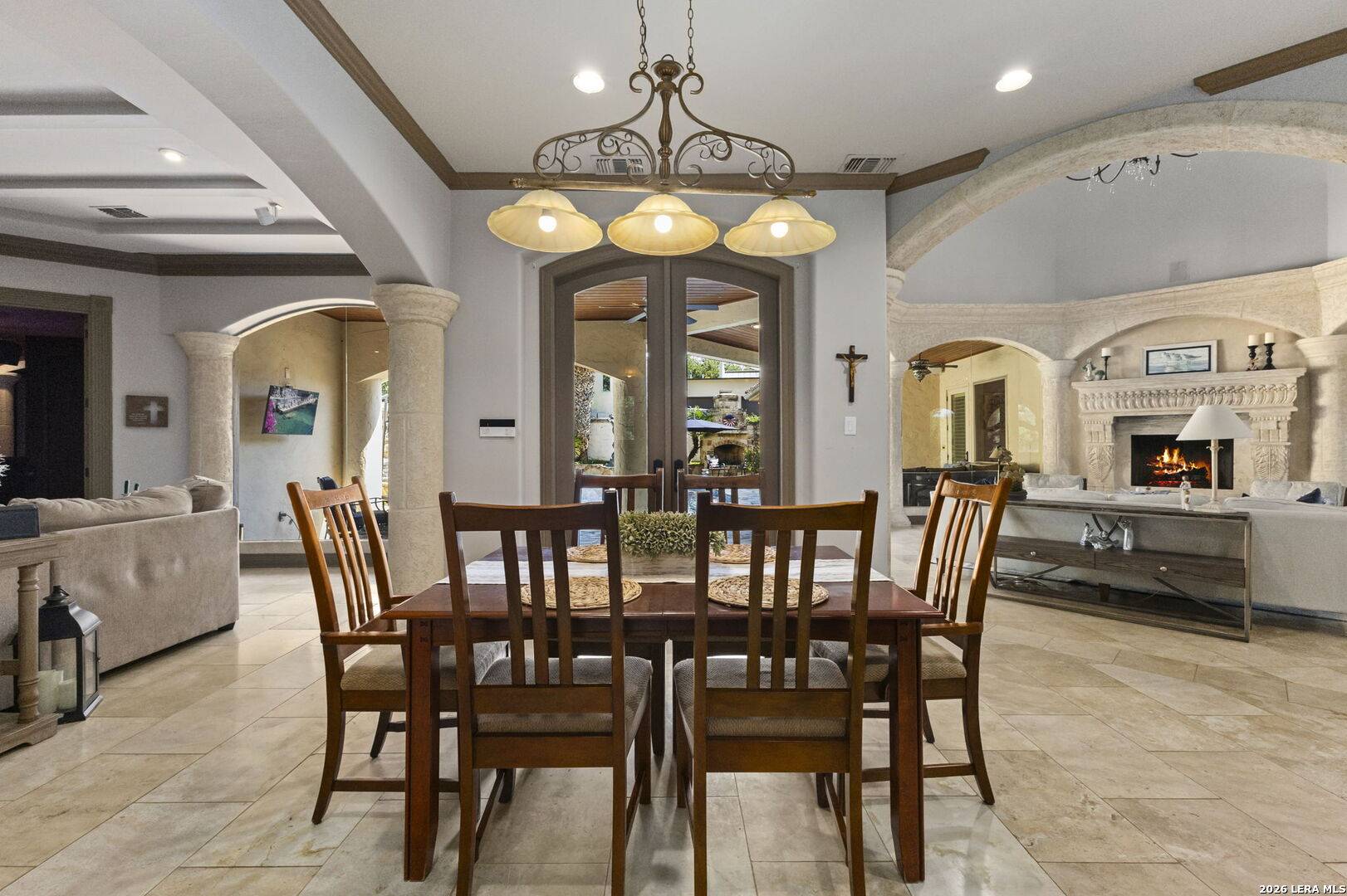 Formal dining room at 2 Belcourt Place with arched openings and travertine floors