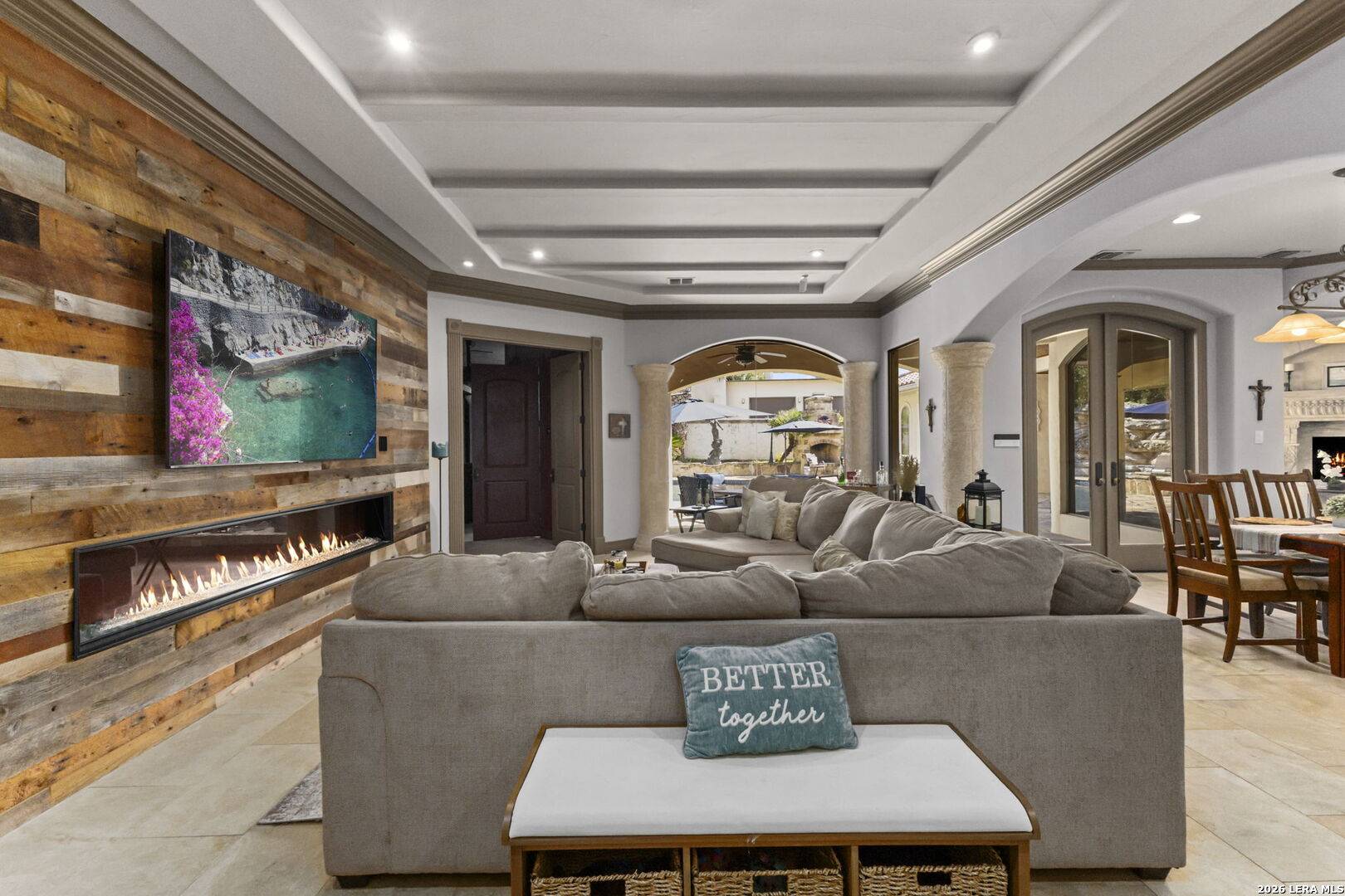 Additional living area at 2 Belcourt Place with linear electric fireplace and coffered ceiling