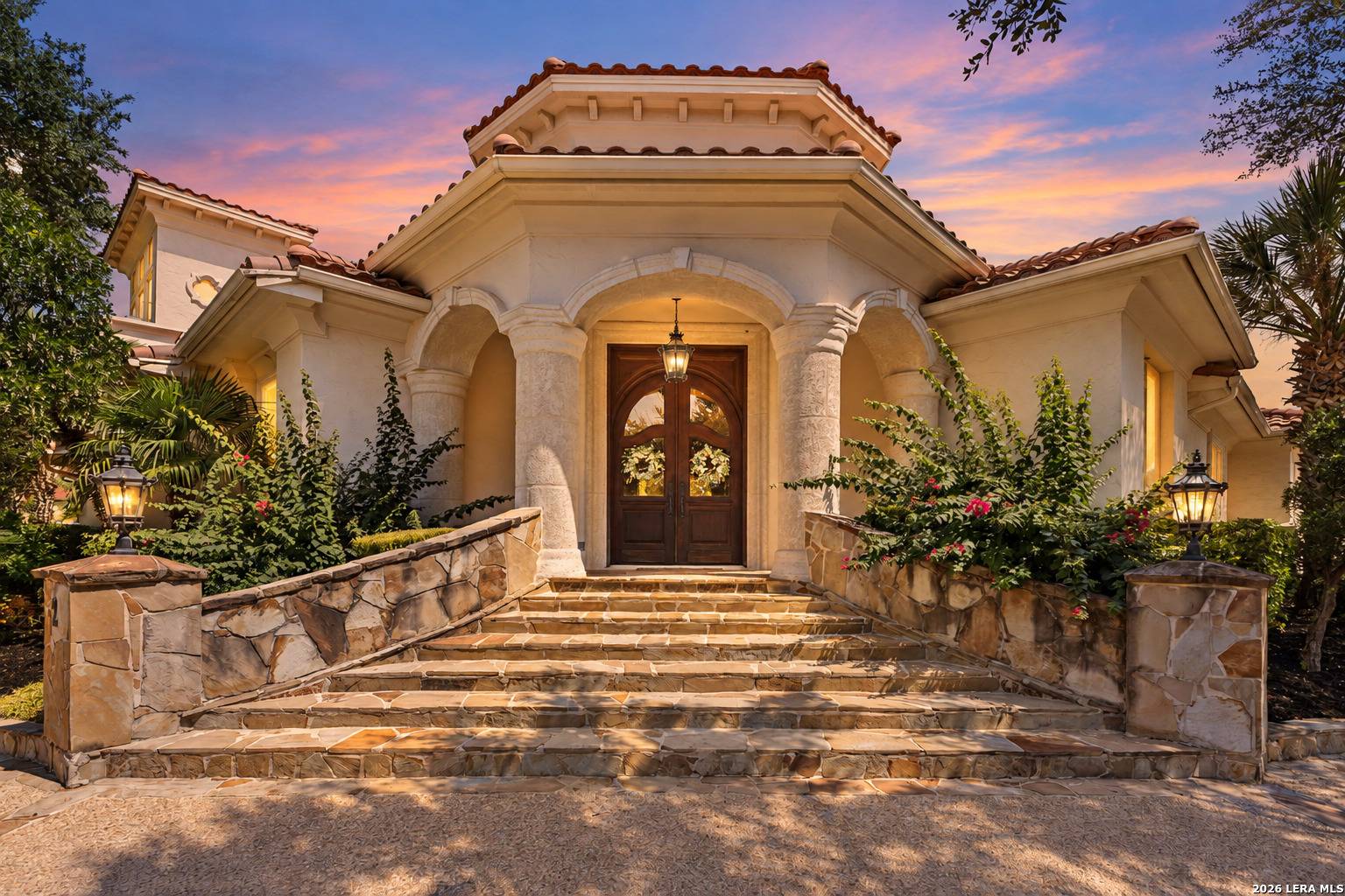 Stone steps and mahogany double doors at the entry of 2 Belcourt Place at dusk