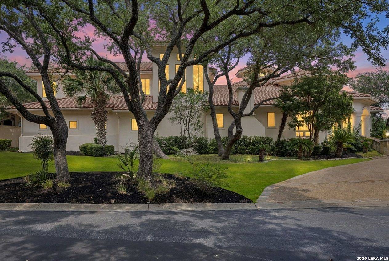 Front elevation of 2 Belcourt Place at twilight beneath mature live oaks, The Dominion, San Antonio